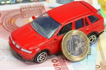 Rotes Spielzeugauto mit Banknoten